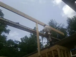 Carpenter setting a ridge beam over a new addition frame — Ice Dam Removal by Roofing Brothers in Heiskell