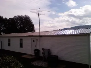 New metal roof on a single wide mobile home with a TV antenna in Heiskell