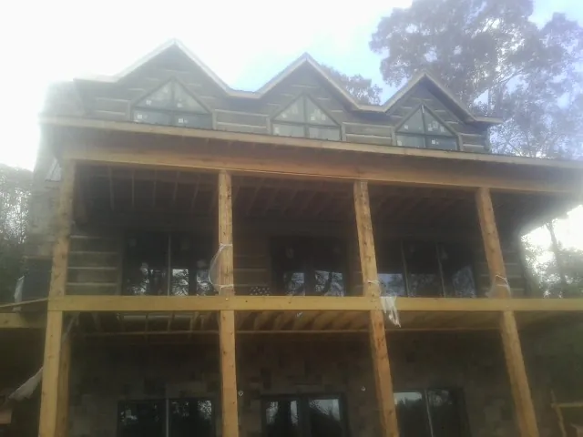 Dormers and porch framing on a large log home under construction — Roof Coating work by our crew in Heiskell