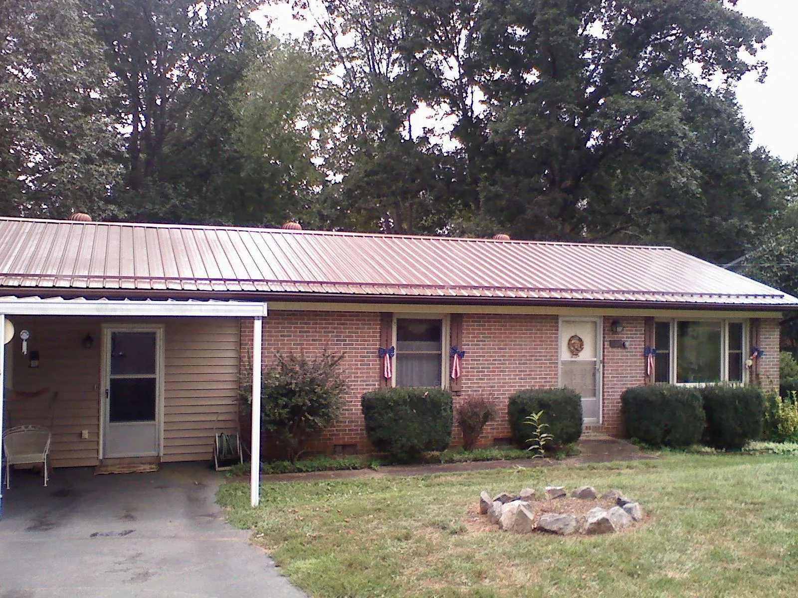 Bronze metal roof and carport on a brick ranch home — Roof Repair work by our crew in Heiskell
